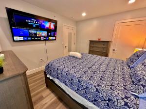 a bedroom with a bed and a tv on the wall at The Classy Suite - 2BR with Free Parking in Paterson