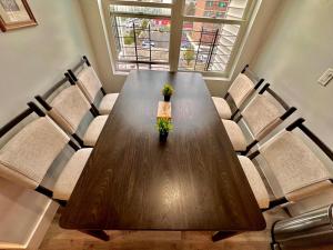 a wooden table with chairs and a vase with flowers at The Classy Suite - 2BR with Free Parking in Paterson