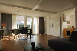 a living room with a dining table and a kitchen at Keizerskroon 237 in Julianadorp +17 photos