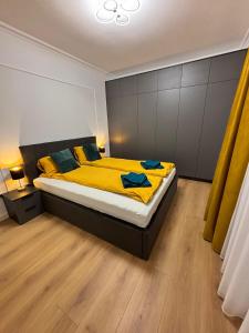 a bedroom with a large bed with yellow sheets at Eden by Mirvana Apartments in Timişoara
