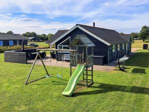 a playground in front of a house with a slide at Luxury Lakeside Retreat - By Traum Ferienwohnungen in Ansager