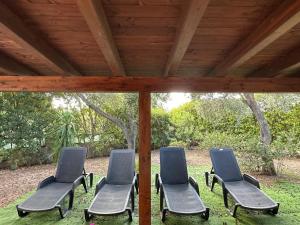 a group of chairs sitting under a roof at Villa il Caminetto in Geremeas +9 photos