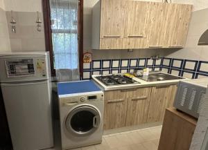 a kitchen with a washing machine and a washer at Villa il Caminetto in Geremeas