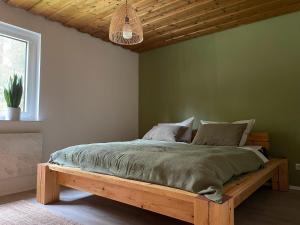 NeubäuにあるFerienhaus am Neubäuer Seeの緑の壁に木製ベッドが備わるベッドルーム1室が備わります。