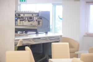 a printer sitting on a table in a room with chairs at Hotel Sans Souci in Rimini
