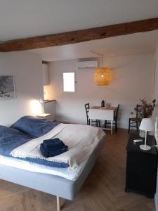 a bedroom with a large bed and a table at Mini-lejlighed med køkken - deler bad og toilet med nabolejlighed 2 in Asperup +10 photos