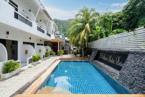 a swimming pool in front of a building at JR Siam Inn Resort in Kata Beach
