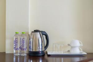 a coffee pot and glasses on a table at JR Siam Inn Resort in Kata Beach