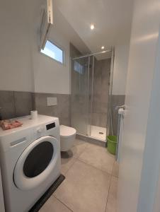 a bathroom with a washing machine and a toilet at Ihr Premium-Zuhause auf Zeit Komfortabel Wohnen in Bestlage in Hannover