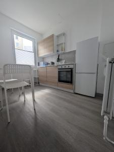 a kitchen with a refrigerator and a table and a chair at Ihr Premium-Zuhause auf Zeit Komfortabel Wohnen in Bestlage in Hannover