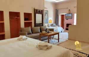 a hotel room with two beds and a living room at Sbai Palace in Mhamid +136 photos