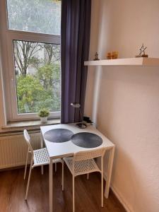 a white table and chairs in a room with a window at 2 Bett Apartment im beliebten östlichen Ringgebiet in Braunschweig