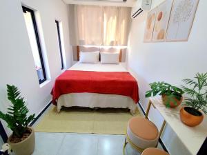 a bedroom with a bed with a red blanket at Casa Container com ar condicionado a 500 m do Mar in Pontal do Paraná
