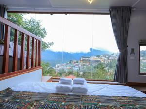una camera da letto con una grande finestra con asciugamani su un letto di Sapa Succulent Garden Homestay - Vườn Sen Đá Homestay a Sa Pa Altre 48 foto