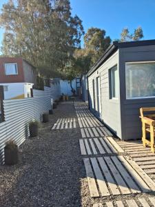 a yard with a tiny house next to a building at Ecos de Mar Refugios in Puerto Pirámides