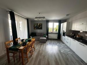een keuken en woonkamer met een tafel en stoelen bij Urban Green Września,Przytulny apartament z parkingiem in Września
