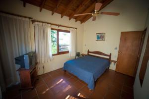 una camera con letto blu e TV di Apart Cabañas Gesell a Villa Gesell Altre 34 foto