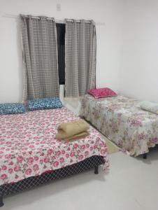 マリカーにあるCasa aconchego - praia, trilhas, comercio, praçaの部屋に並んで置かれた2つのベッド