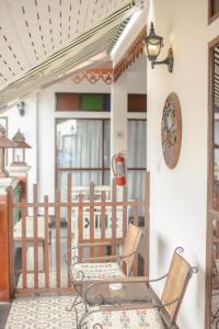 a porch with two chairs and a clock on the wall at Hetai Boutique Hotel in Chiang Mai