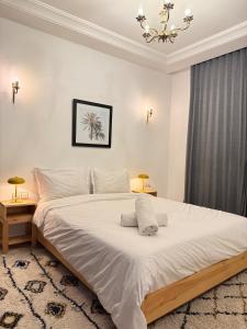 a bedroom with a large white bed with a chandelier at Dar Mogador in Essaouira