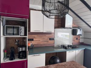 Una cocina con gabinetes blancos y encimera. en dépendance de la Métairie, en Bignan 10 fotos más