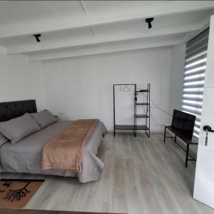 Casa Árbol lodge في بابودو: غرفة نوم بيضاء بسرير وكرسي