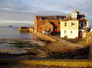 a house on the shore of a body of water at Coastal Escape 3 Bed Apartment Near the Beach in North Berwick +19 photos