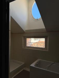 a bathroom with a bath tub and a window at Appartement- cœur de Cannes in Cannes