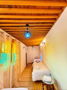 a bedroom with two beds and a wooden ceiling at Riad Ayoub Fes in Fès