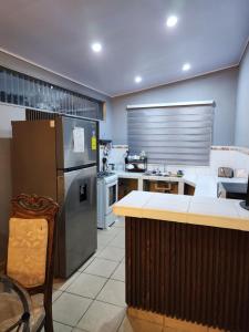 a large kitchen with a refrigerator and a counter at Townhouse in Siguatepeque