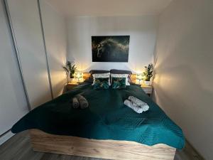 1 dormitorio con 1 cama verde grande y 2 lámparas en Urban Green Września,Przytulny apartament z parkingiem, en Września