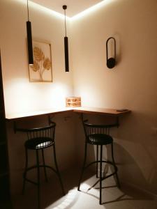 a kitchen with two bar stools and a counter with lights at Комфортная квартира в центре города in Almaty