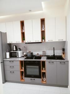 a kitchen with white cabinets and a sink at Комфортная квартира в центре города in Almaty +28 photos
