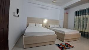 BograにあるHotel Lynn Valleyのベッドルーム1室(ベッド2台付)、窓、ドアが備わります。
