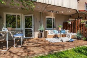 a patio with a couch and chairs on a wooden deck at Spacious Apartment in Sodermalm in Stockholm