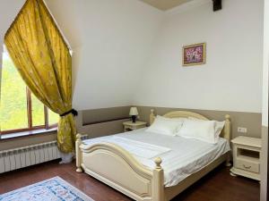 a bedroom with a white bed and a window at Promenade Park Hotel in Shymkent