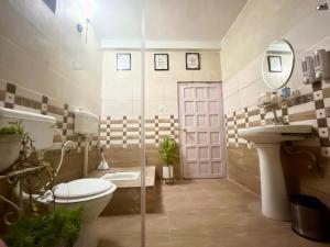 a bathroom with a toilet and a sink and a door at Winterline Vista in Rānīkhet +58 photos