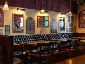 a restaurant with tables and chairs and posters on the wall at APA Hotel Nagasaki Ekimae in Nagasaki