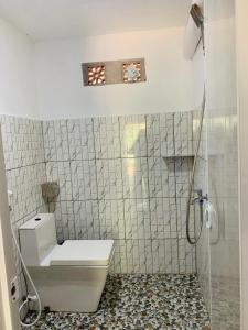 a white bathroom with a toilet and a shower at Nova Homestay in Kuta Lombok