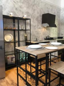 une cuisine avec une table avec des assiettes dessus dans l'établissement Spàzio apartments Alcalà, à Catane 12 autres photos