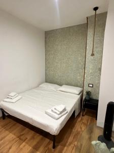 a bedroom with a white bed with towels on it at Spàzio apartments Alcalà in Catania