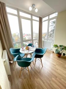 a dining room with a table and four chairs at Затишна красива студія в новобудові з балконом in Chernivtsi