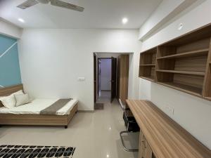a bedroom with a bed and a desk in it at the varun residency in Greater Noida