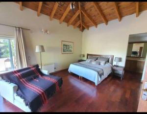 a bedroom with two beds and a couch in it at Tu Casa de Campo - Confort, Hogar & Naturaleza in Estancia Grande