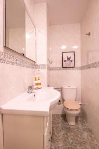 Un baño blanco con lavabo e inodoro. en Grace Pool Apartment Benalmádena, en Benalmádena 18 fotos más