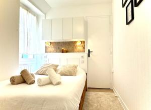 una camera da letto bianca con un letto e una finestra di L'Écrin d'Or - Élégant & Confortable- Idéalement Situé en Centre-Ville - Terrasse - Gare à 5 min a Valence