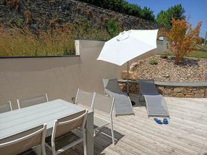 a table and chairs and an umbrella on a deck at Gîte atypique plus haut de Vendée 10mn Puy duFou in Saint-Michel-Mont-Mercure