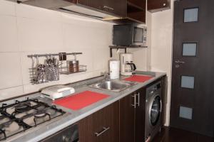 a kitchen with a sink and a washing machine at Casa M&R in Bucharest