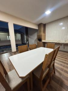 une salle à manger avec une table et des chaises blanches dans l'établissement Casa Recanto da Paz Premium 2025, à Gurupi