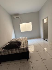 une chambre blanche avec un lit et une fenêtre dans l'établissement Casa Recanto da Paz Premium 2025, à Gurupi 7 autres photos